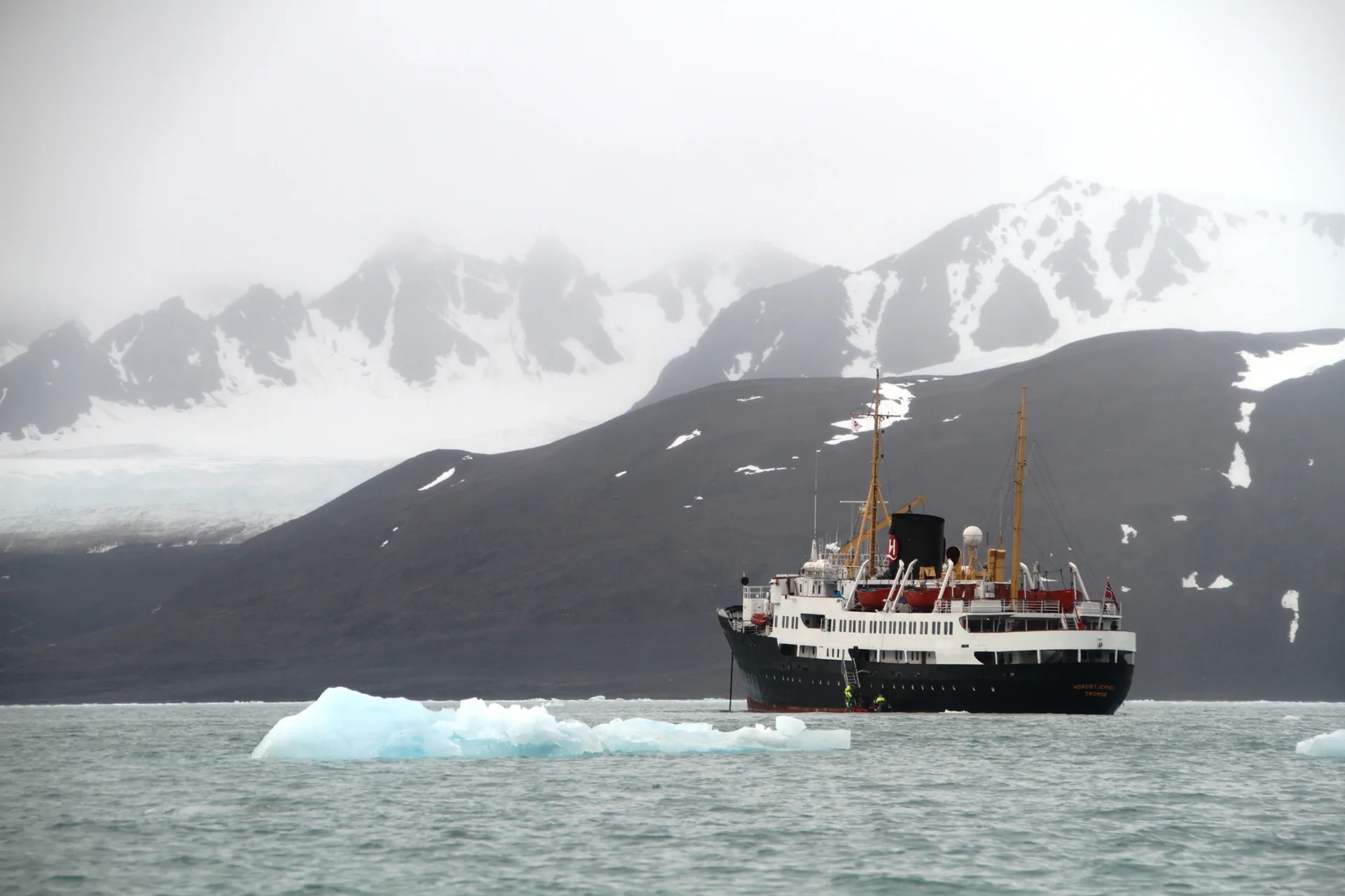 Navire devant les montagnes enneigées du Svalbard